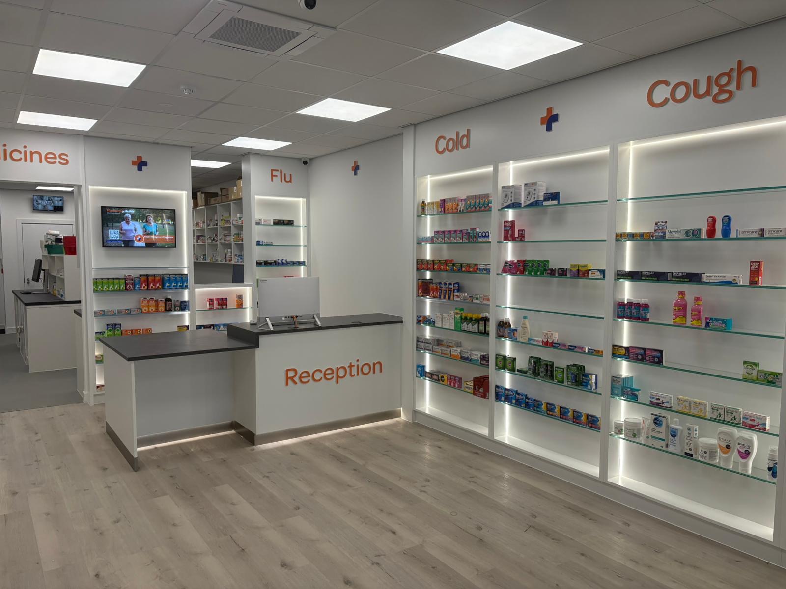 Completed pharmacy interior with illuminated display shelving and reception desk
